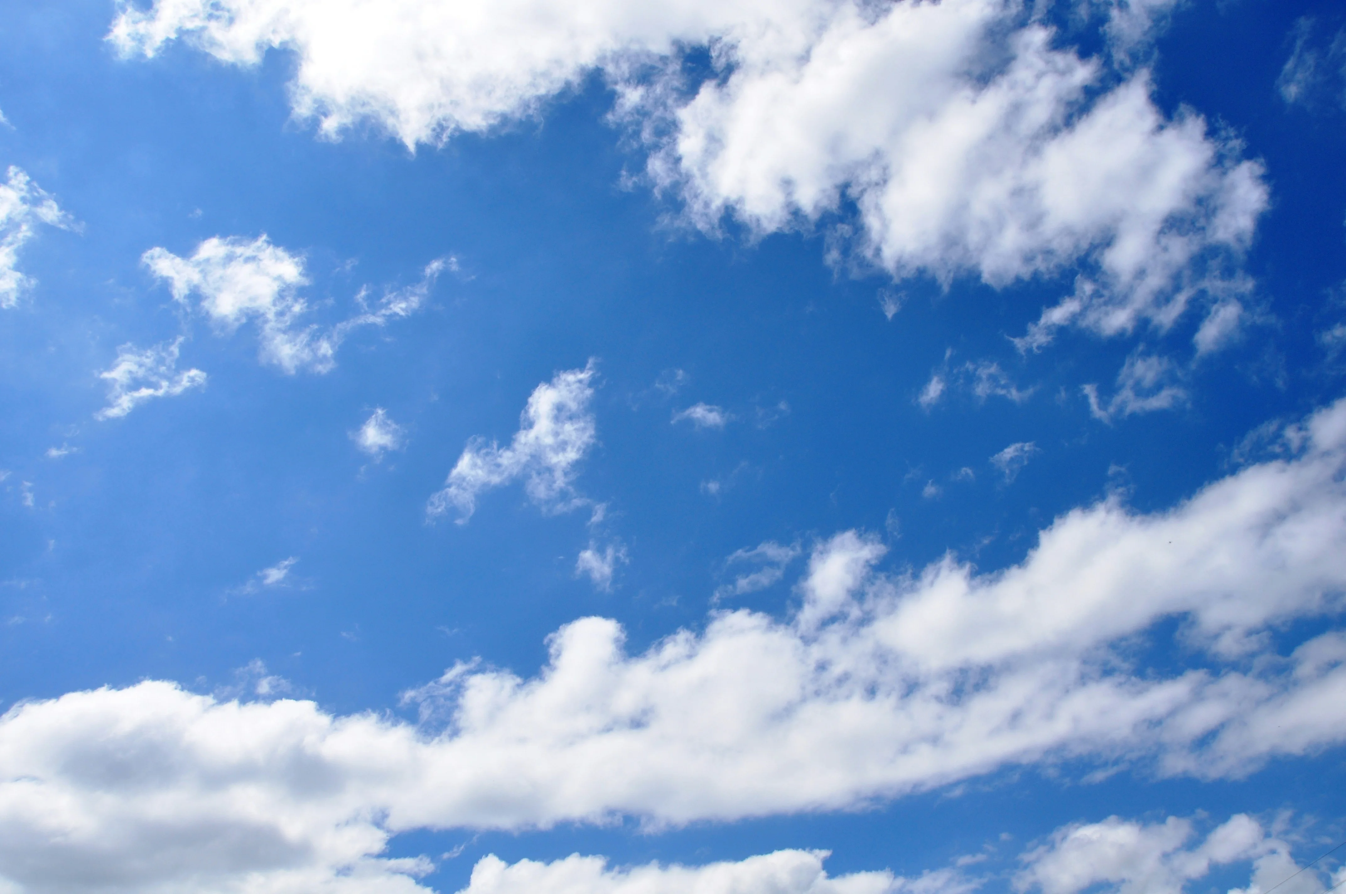 Open blue sky with soft white clouds
