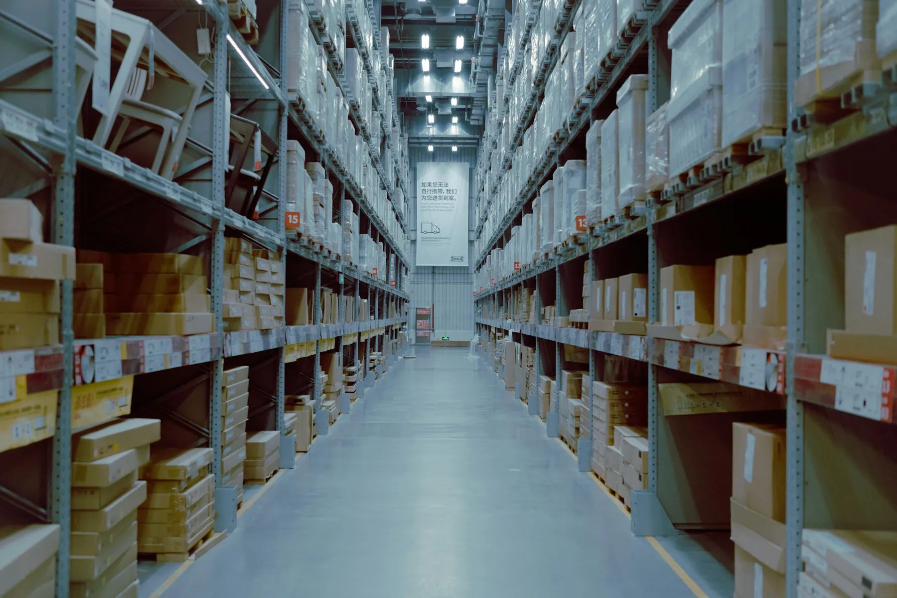Long aisle of shelves inside a large warehouse